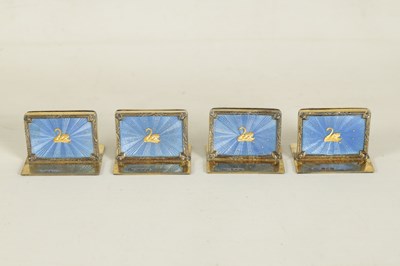 Lot 479 - A CASED SET OF FOUR SILVER GILT AND BLUE GUILLOCHE ENAMEL MENU HOLDERS