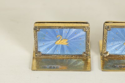 Lot 479 - A CASED SET OF FOUR SILVER GILT AND BLUE GUILLOCHE ENAMEL MENU HOLDERS