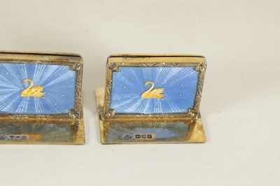 Lot 479 - A CASED SET OF FOUR SILVER GILT AND BLUE GUILLOCHE ENAMEL MENU HOLDERS