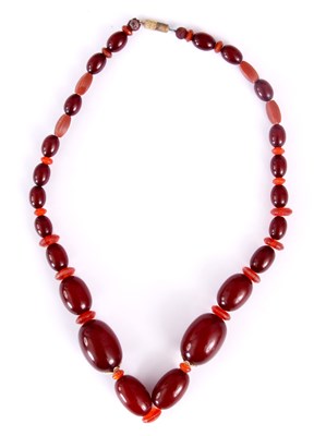 Lot 367 - A RED AMBER BEAD NECKLACE of oval graduated...