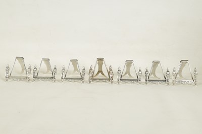 Lot 438 - A SET OF SEVEN SILVER FIGURAL MENU HOLDERS