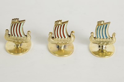 Lot 389 - A SET OF FOUR NORWEGIAN SILVER GILT AND ENAMEL VIKING SHIP MENU HOLDERS