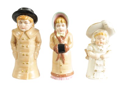 Lot 32 - GIRL WITH MUFF AND BOY WITH BOATER. A PAIR OF ROYAL WORCESTER CANDLE EXTINGUISHERS