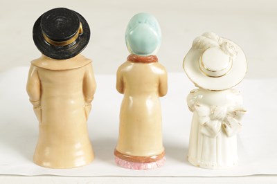 Lot 32 - GIRL WITH MUFF AND BOY WITH BOATER. A PAIR OF ROYAL WORCESTER CANDLE EXTINGUISHERS
