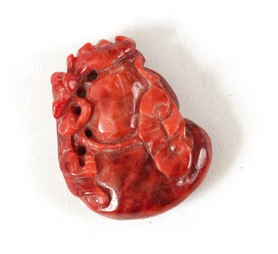 Lot 167 - A CHINESE RED JADE CARVED AND PIERCED SCULPTURE