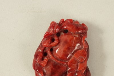 Lot 167 - A CHINESE RED JADE CARVED AND PIERCED SCULPTURE