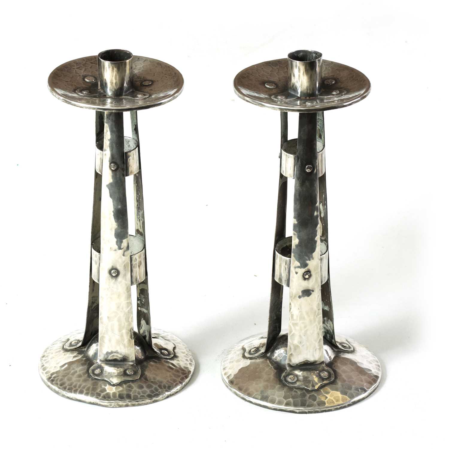 Lot 431 - A PAIR OF ARTS AND CRAFTS PLEMISHED SILVERED COPPER STYLISED CANDLESTICKS