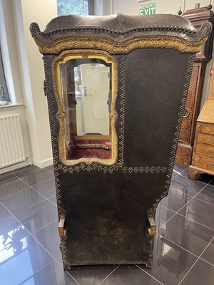 Lot 103 - AN EARLY/MID18TH CENTURY CARVED GILT-WOOD AND STUDDED LEATHER SEDAN CHAIR