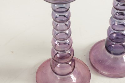 Lot 8 - A PAIR OF EARLY 20TH CENTURY IRIDESCENT AUBERGINE GLASS CANDLESTICKS