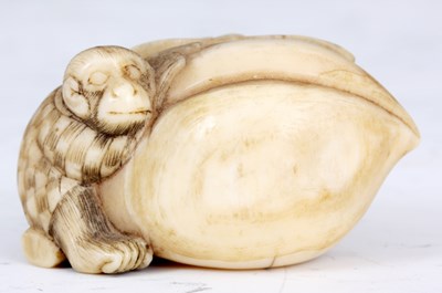 Lot 107 - A JAPANESE IVORY SCULPTURE of a monkey holding...