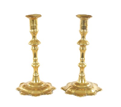 Lot 518 - A PAIR OF EARLY 18TH CENTURY SEAMED BRASS PETAL BASE CANDLESTICKS