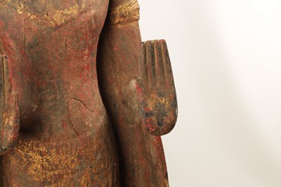 Lot 123 - AN EARLY TIBETAN LIFE-SIZE GILT AND RED LACQUER CARVED STANDING FIGURE OF A BUDDHA