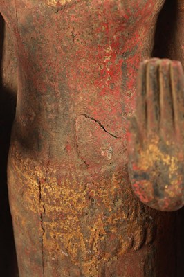 Lot 123 - AN EARLY TIBETAN LIFE-SIZE GILT AND RED LACQUER CARVED STANDING FIGURE OF A BUDDHA