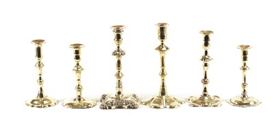 Lot 510 - A SELECTION OF PETAL BASED SEAMED BRASS CANDLESTICKS AND A RARE CAST BRASS ROCOCO STYLE CANDLESTICK