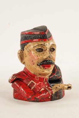 Lot 577 - AN EARLY 20TH CENTURY PAINTED CAST IRON MECHANICAL "KILTIE" MONEY BOX