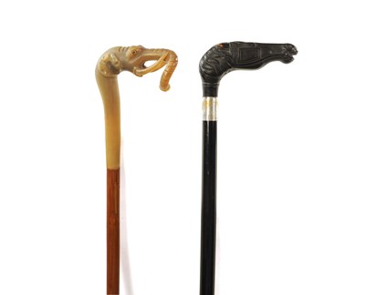 Lot 567 - A 19TH CENTURY EBONISED WALKING CANE AND ANOTHER ELEPHANT’S HEAD WALKING STICK