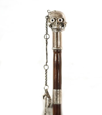 Lot 574 - AN UNUSUAL 19TH CENTURY SILVER TOPPED WALKING STICK WITH HINGED SKULL POMMEL