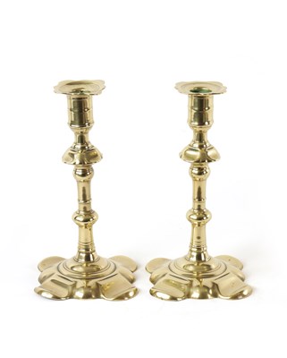 Lot 393 - A PAIR OF EARLY 18TH CENTURY SEAMED BRASS PETAL BASE CANDLESTICKS