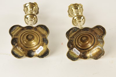 Lot 658 - A PAIR OF EARLY 18TH CENTURY SEAMED BRASS PETAL BASE CANDLESTICKS