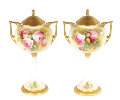 Lot 48 - A PAIR OF ROYAL WORCESTER LIDDED PEDESTAL VASES DECORATED WITH ROSES