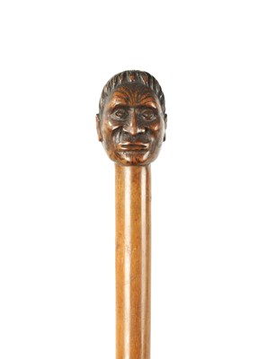 Lot 397 - A LATE 19TH CENTURY CARVED HARDWOOD WALKING STICK FORMED AS A MĀORI