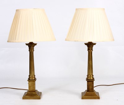 Lot 555 - A PAIR OF BRASS CORINTHIAN LAMPS 47cm high.