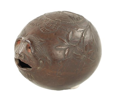 Lot 1070 - AN EARLY 19TH CENTURY EASTERN CARVED COCONUT BUGBEAR MONEYBOX