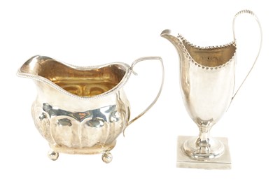 Lot 717 - A GEORGE III HELMET CREAM JUG AND MILK JUG