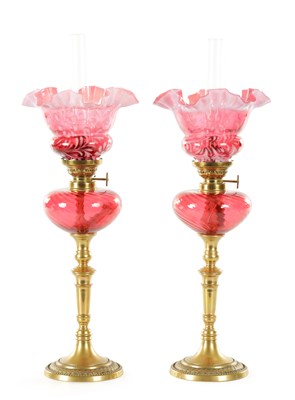 Lot 839 - A PAIR OF BRASS AND CRANBERRY GLASS OIL LAMPS