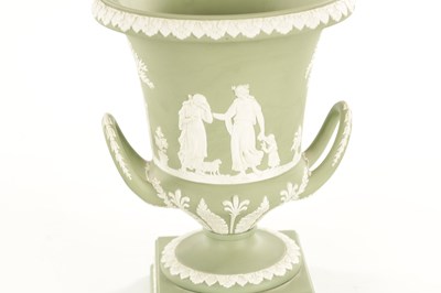 Lot 65 - A WEDGWOOD GREEN JASPER WARE TWO-HANDLED URN SHAPED VASE AND COVER ON PEDESTAL BASE