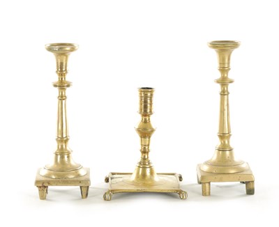 Lot 563 - AN EARLY CAST BRASS SPANISH CANDLESTICK TOGETHER WITH A SIMILAR PAIR OF CAST BELL METAL SPANISH CANDLESTICKS