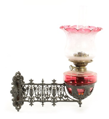 Lot 704 - A 19TH CENTURY HANGING CAST IRON AND CRANBERRY OIL LAMP