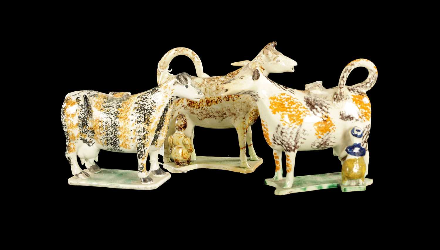 Lot 61 - THREE EARLY 19TH CENTURY NORTH ENGLAND POTTERY COW CREAMERS