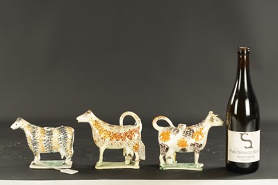 Lot 61 - THREE EARLY 19TH CENTURY NORTH ENGLAND POTTERY COW CREAMERS