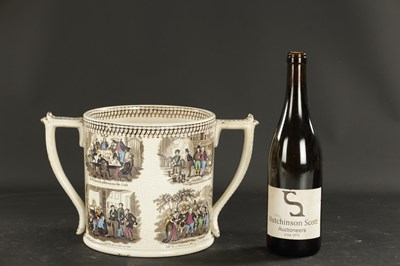 Lot 369 - A LARGE NORTH EAST POTTERIES LOVING CUP PRINTED AND PAINTED WITH DICKENSIAN CHARACTERS