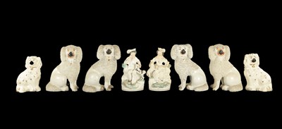 Lot 269 - TWO PAIRS OF STAFFORDSHIRE POODLES AND A PAIR OF LATE SPANIELS