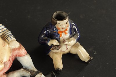 Lot 329 - A STAFFORDSHIRE TABACO JAR IN THE FORM OF A MAN AND A SMALLER SIMILAR EXAMPLE