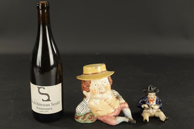 Lot 329 - A STAFFORDSHIRE TABACO JAR IN THE FORM OF A MAN AND A SMALLER SIMILAR EXAMPLE