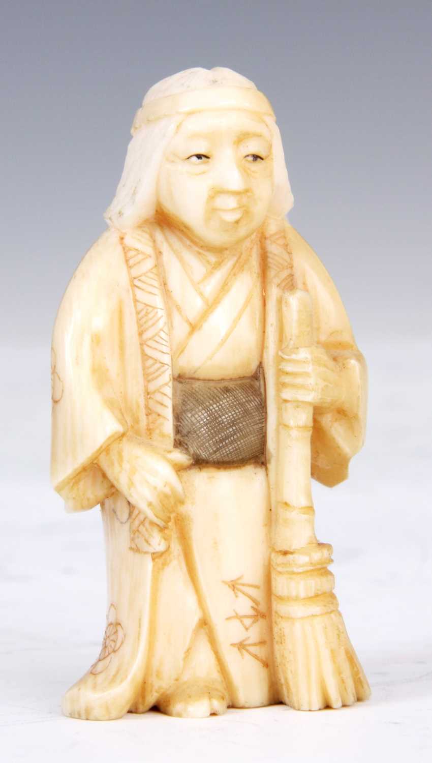 Lot 106 - A JAPANESE IVORY SCULPTURE of an oriental man...