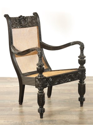 Lot 136 - A 19TH CENTURY CEYLONESE SOLID EBONY BERGERE ARMCHAIR