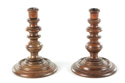 Lot A PAIR OF 19TH CENTURY TURNED WALNUT TREENWARE CANDLESTICKS