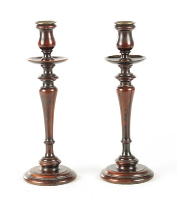 Lot A PAIR OF GEORGE III TURNED MAHOGANY CANDLESTICKS