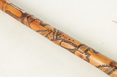 Lot 515 - AN EARLY 20TH CENTURY JAPANESE CARVED BAMBOO CARVED STICK WITH FITTED TELESCOPIC FISHING ROD