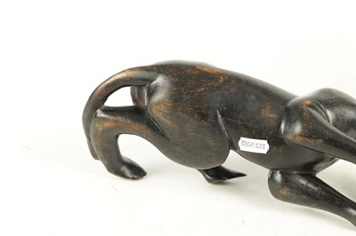 Lot 894 - A 19TH/EARLY 20TH CENTURY CARVED STAINED HARDWOOD SCULPTURE OF A RECUMBENT BIG CAT