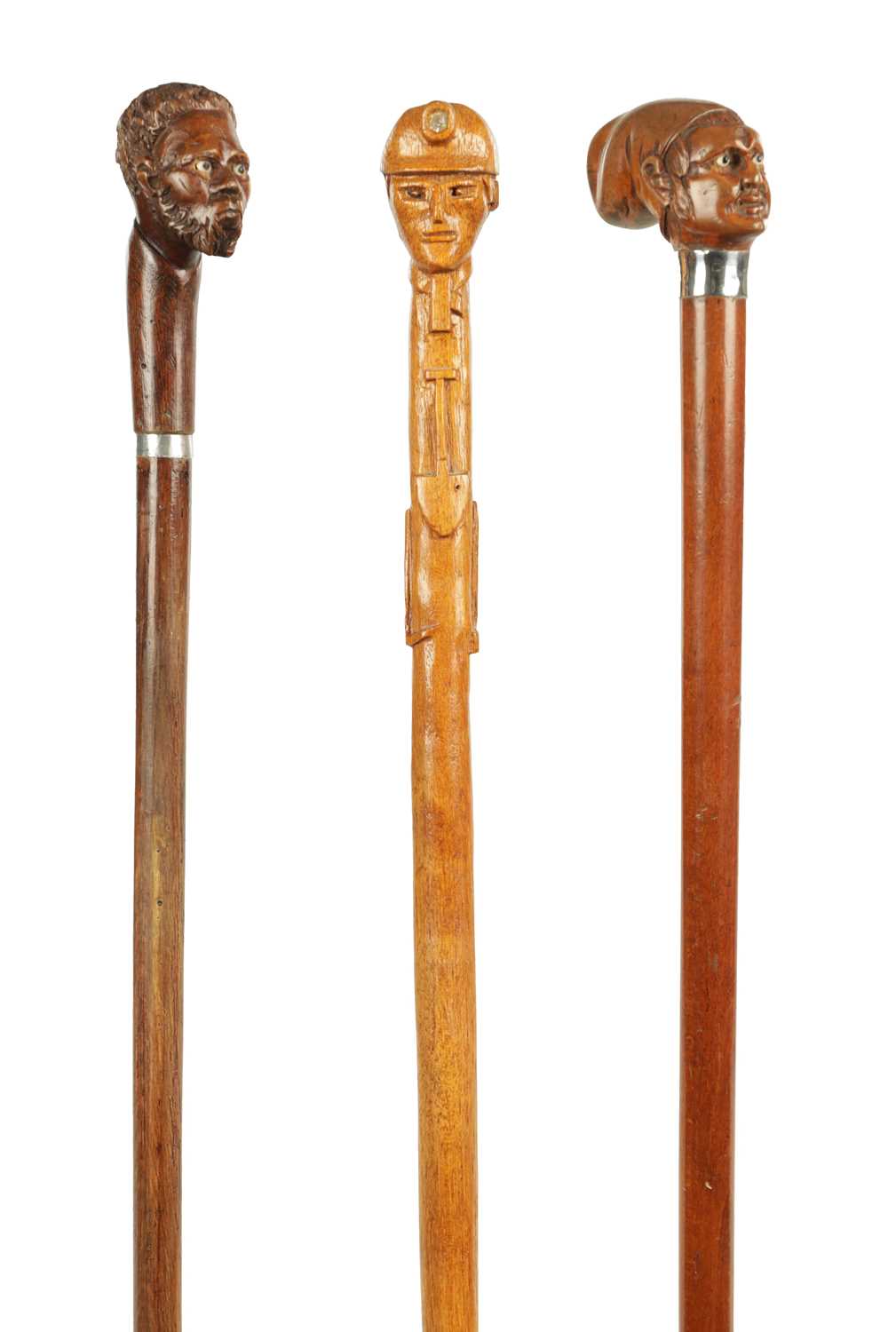 Lot 496 - A COLLECTION OF THREE LATE 19TH CENTURY CARVED WOOD MASK HEAD WALKING STICKS