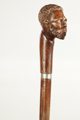 Lot 496 - A COLLECTION OF THREE LATE 19TH CENTURY CARVED WOOD MASK HEAD WALKING STICKS