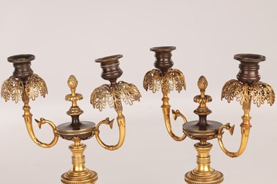 Lot 730 - A PAIR OF REGENCY FRENCH BRONZE AND GILT BRONZE TWO BRANCH CANDELABRA
