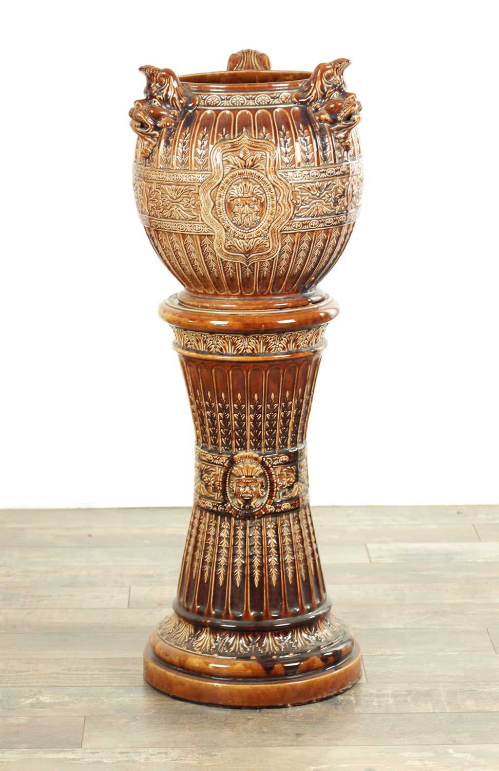 Lot 29 - A 19TH CENTURY TREACLE GLAZED MAJOLICA JARDINIERE ON STAND