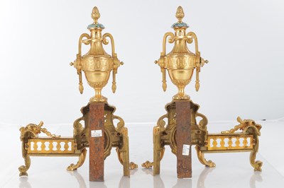 Lot A PAIR OF LATE 19TH CENTURY FRENCH ORMOLU AND CHAMPLEVE ENAMELLED FIRE DOGS
