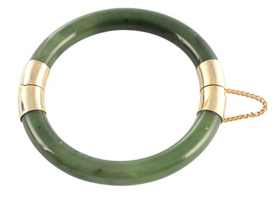 Lot 178 - AN ORIENTAL SAGE GREEN JADE AND GOLD METAL MOUNTED BANGEL